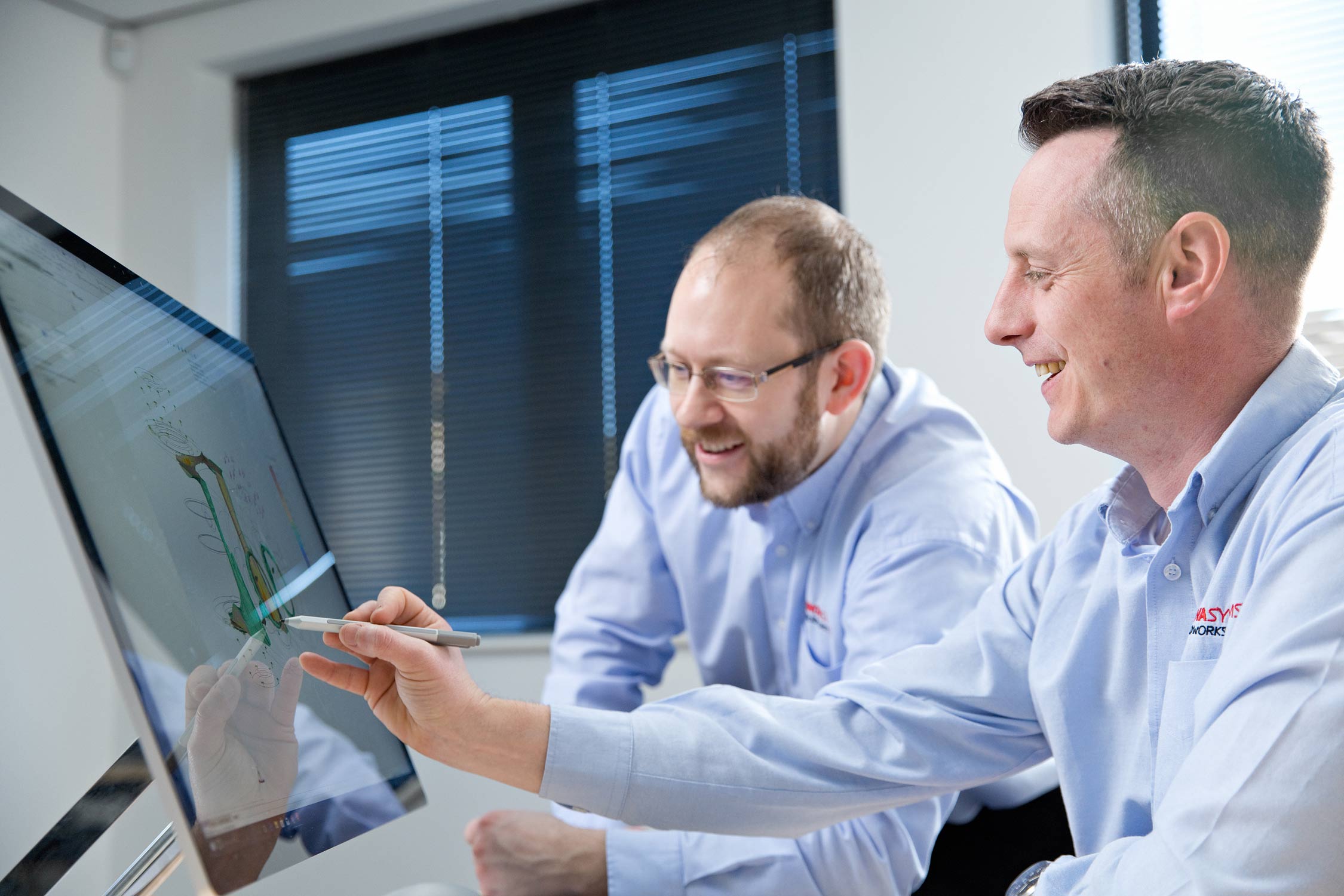 Business and office PR photography of two employees working together at a computer.