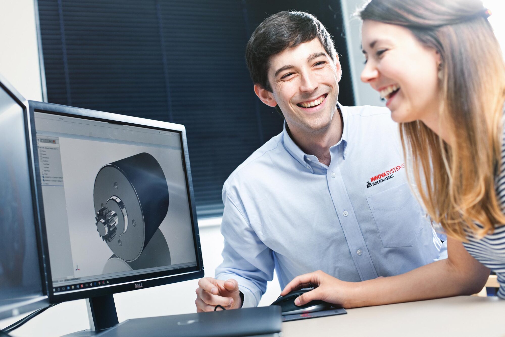 Business and office PR photography of two employees working together at a computer.